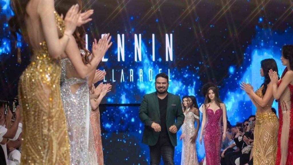 Lenin Villarroel presenta su colección en la pasarela de Chile Fashion Week rodeado de modelos en vestidos de alta costura. Fotografia oficial de Chile Fashion Week 2025
