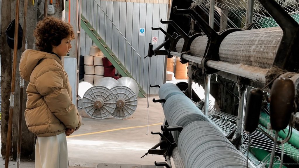 Imagen de Max Alexander en Chile, visitando fábrica textil. Imagen sacada de historias de Instagram del diseñador y mejorada en calidad con IA.